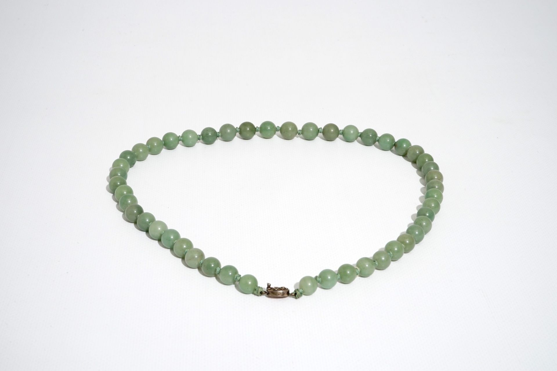 A Chinese green jade beads necklace with silver lock, 19/20th C. - Image 2 of 5
