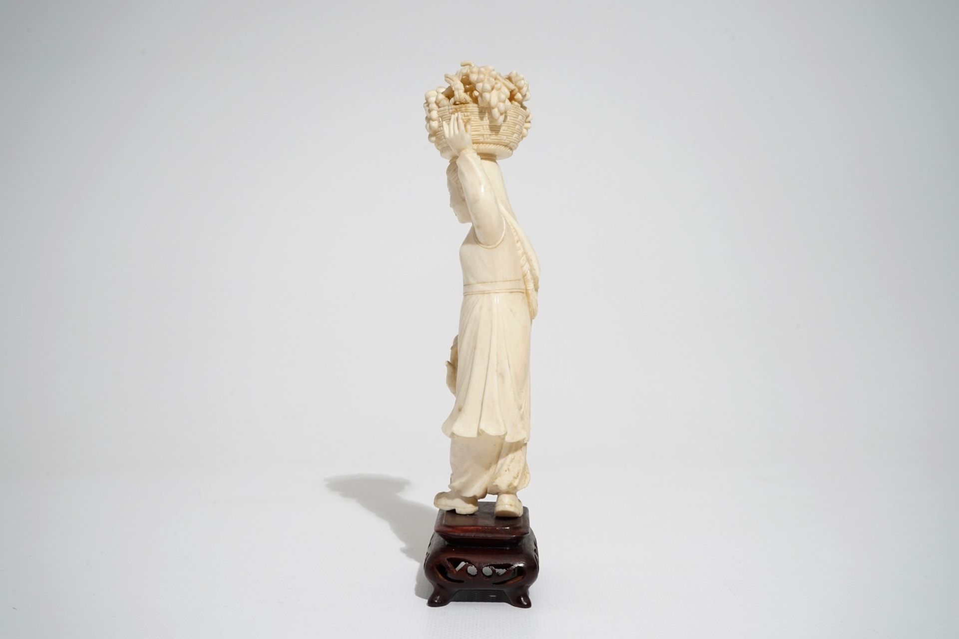 A Chinese carved ivory figure of a lady with a fruit basket, 2nd quarter 20th C. - Image 3 of 7