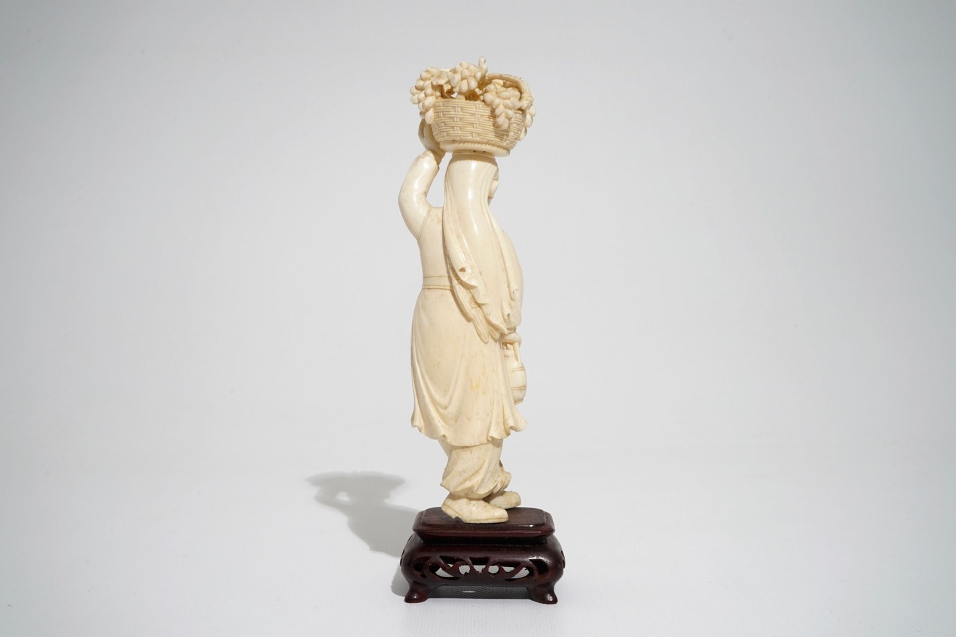 A Chinese carved ivory figure of a lady with a fruit basket, 2nd quarter 20th C. - Image 4 of 7