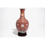 A Chinese red-ground famille rose bottle vase, Qianlong mark, 19/20th C.