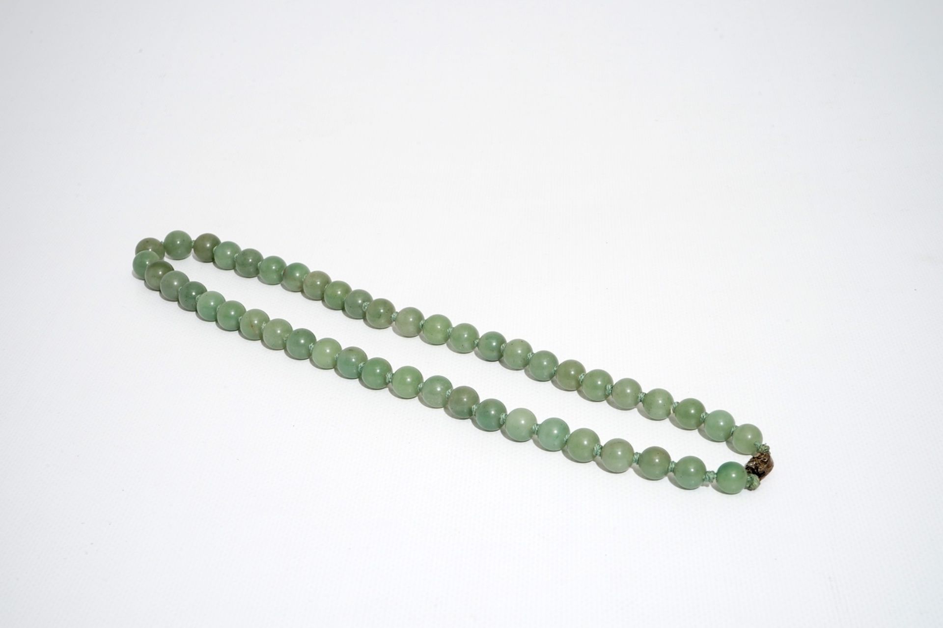 A Chinese green jade beads necklace with silver lock, 19/20th C. - Image 3 of 5