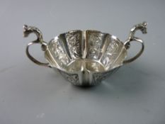 A SMALL OVAL GEORGIAN SILVER TWIN HANDLED TASTER BOWL, the body of floral segmented panels and