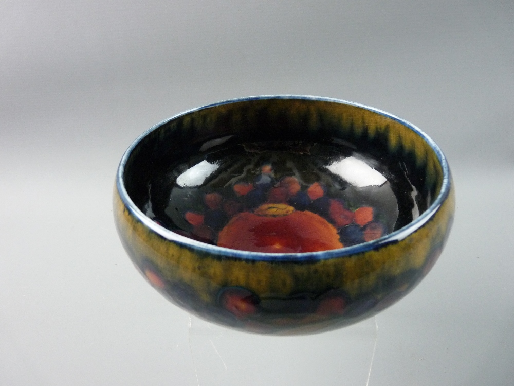 A MOORCROFT POMEGRANATE FOOTED BOWL, 16 cms diameter, decorated on a cobalt blue ground, impressed