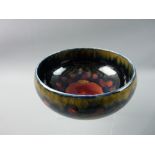 A MOORCROFT POMEGRANATE FOOTED BOWL, 16 cms diameter, decorated on a cobalt blue ground, impressed