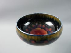 A MOORCROFT POMEGRANATE FOOTED BOWL, 16 cms diameter, decorated on a cobalt blue ground, impressed