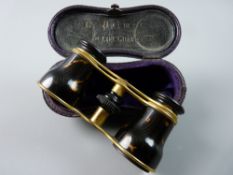 A CASED PAIR OF BRASS AND BELIEVED TORTOISESHELL OPERA GLASSES and the interior lid of the faux