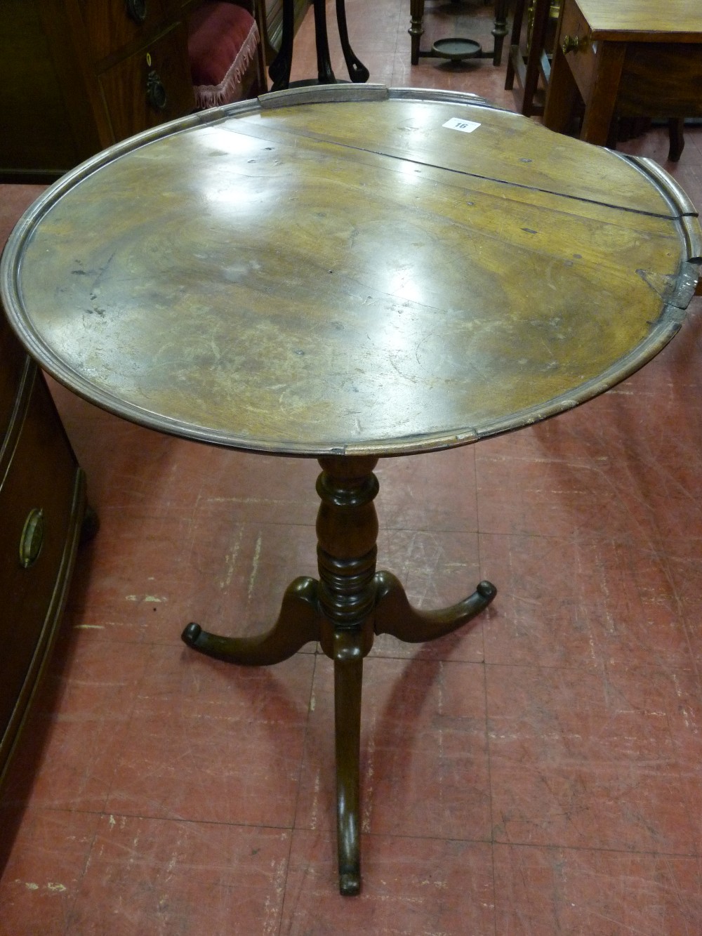 A GEORGIAN MAHOGANY TILT TOP TABLE, the tray top on a turned column with tripod base (splits and