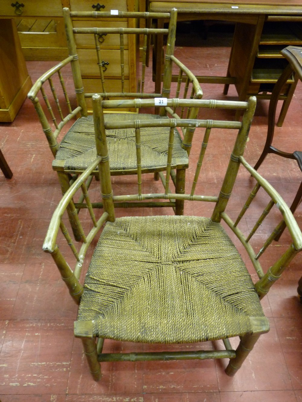 A PAIR OF FAUX BAMBOO ARMCHAIRS, late 18th/early 19th Century, rush seated with curved arms and with