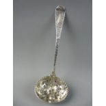 AN ORNATE SILVER SUGAR SIFTER, the bowl with raised fruit and leaf decoration and the handle with