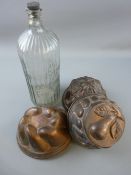 THREE VINTAGE TINWARE COPPER COLOURED JELLY MOULDS and a large ribbed 'Poison' bottle, 37 cms high