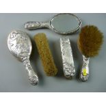 A HALLMARKED SILVER FIVE PIECE MIRROR AND BRUSH SET with embossed Art Nouveau pattern of maiden's
