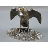 A WHITE METAL EAGLE DESK STAND, the bird with outstretched wings standing on a rocky base, the