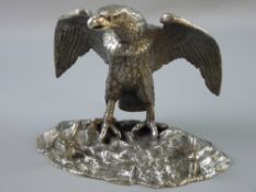 A WHITE METAL EAGLE DESK STAND, the bird with outstretched wings standing on a rocky base, the