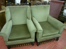 A GOOD PAIR OF OAK AND UPHOLSTERED ARMCHAIRS having leaf carved top rails with bobbin finials, green