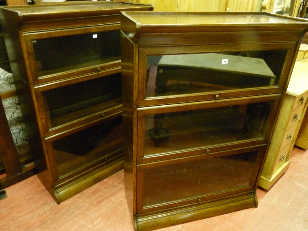 AN EXCELLENT PAIR OF OAK STACKING BOOKCASES, both three section with glazed lifting doors and shaped