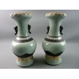 A PAIR OF ORIENTAL CELADON CRACKLE GLAZED NARROW NECKED BULBOUS VASES with elephant trunk handles