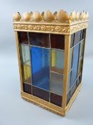 A SQUARE COLOURED GLASS METAL FRAMED HANGING LANTERN, each side having eleven coloured and leaded