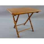 AN EARLY TO MID 20th CENTURY POLISHED FOLDING MINIATURE TABLE having an oblong top and with bamboo