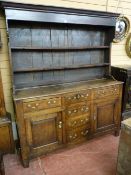 A GEORGE III OAK NORTH WALES DRESSER, the extended canopy wide boarded rack with two shelves and