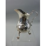 A VICTORIAN SILVER CREAM JUG of waisted form with raised floral and scrolled decoration on three web