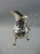 A VICTORIAN SILVER CREAM JUG of waisted form with raised floral and scrolled decoration on three web