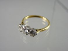 AN EIGHTEEN CARAT GOLD THREE STONE DIAMOND RING, claw set round brilliant cut stones with a combined