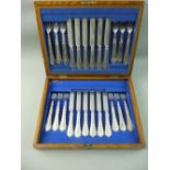 A WOODEN CANTEEN OF EARLY 20th CENTURY DESSERT/FRUIT KNIVES AND FORKS, twelve knives and twelve