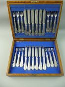 A WOODEN CANTEEN OF EARLY 20th CENTURY DESSERT/FRUIT KNIVES AND FORKS, twelve knives and twelve