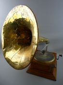 AN OAK CASED VINTAGE WIND-UP GRAMOPHONE with large brass horn, trade stamped to the front '