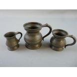A GRADUATED SET OF THREE PEWTER RUM MEASURES, quarter gill, half gill and one gill, each