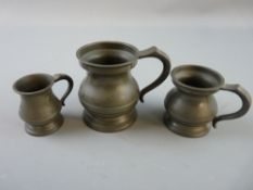 A GRADUATED SET OF THREE PEWTER RUM MEASURES, quarter gill, half gill and one gill, each