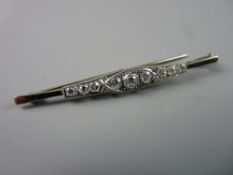 AN EIGHTEEN CARAT PLATINUM OBLONG BAR BROOCH, the shaped bar having a centre round cut diamond,