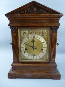 A CIRCA 1900 GERMAN OAK CASED MANTEL CLOCK, the architectural styled case with brass face,