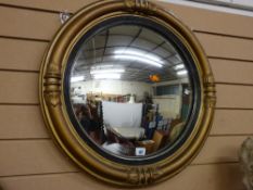 A REGENCY STYLE CONVEX WALL MIRROR with pillar and cap decoration and ebonized interior slip, 62 cms