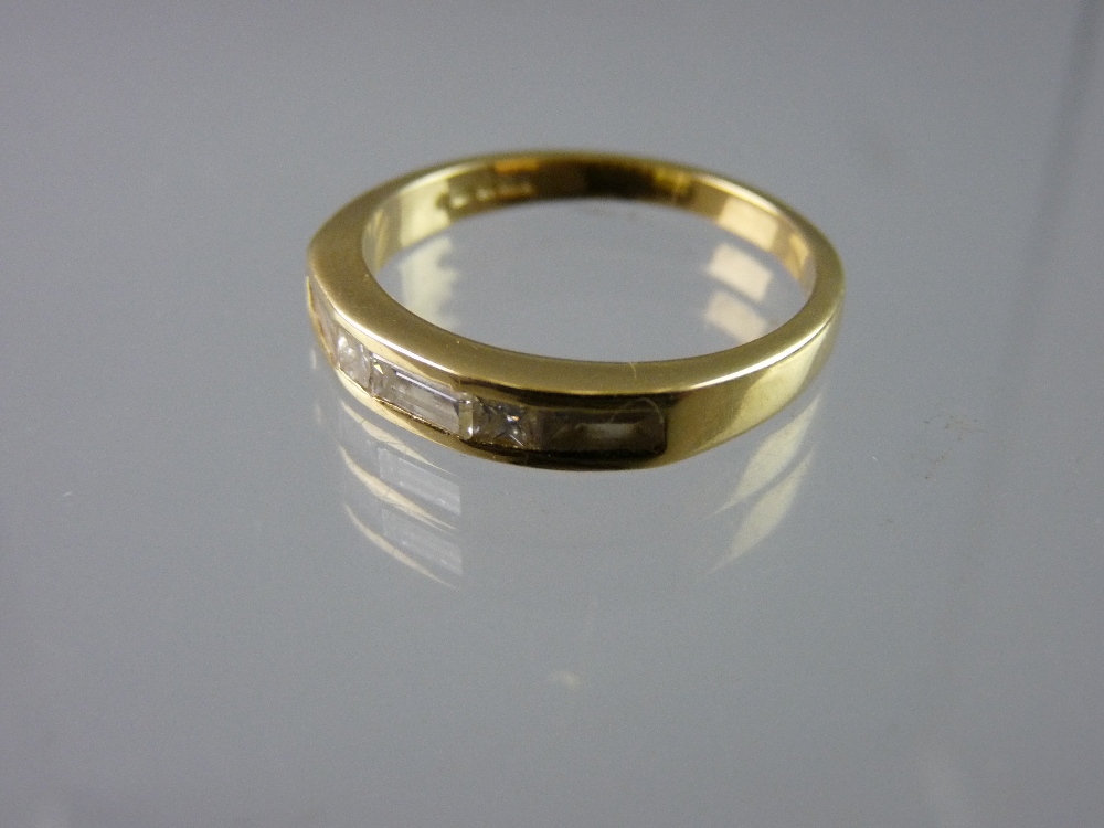 AN EIGHTEEN CARAT GOLD DRESS RING, 4.5 grms total with a one third hoop band of three oblong cut