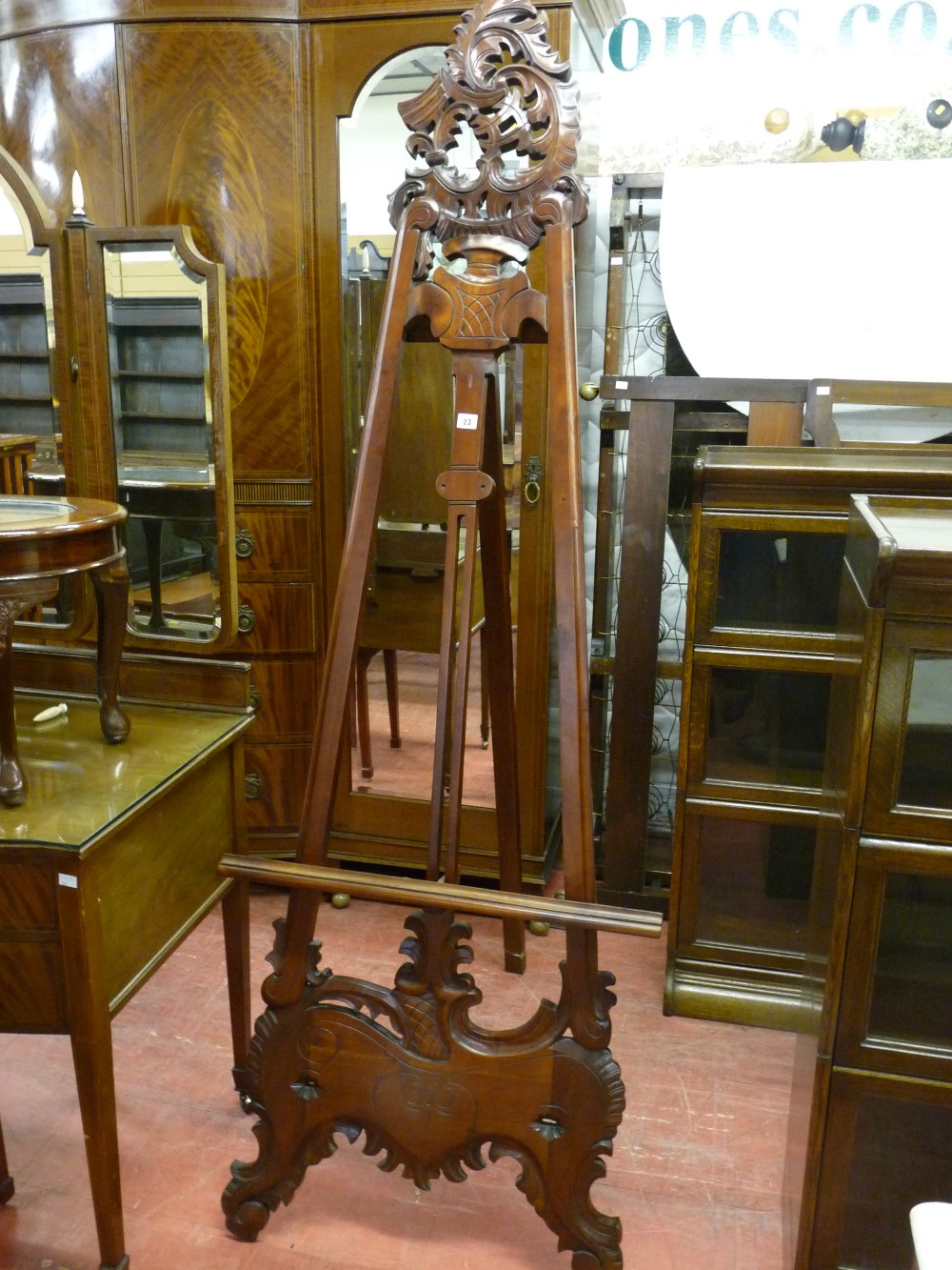 A CARVED MAHOGANY EASEL, reproduction with pierced decoration to the upper and lower sections, 212