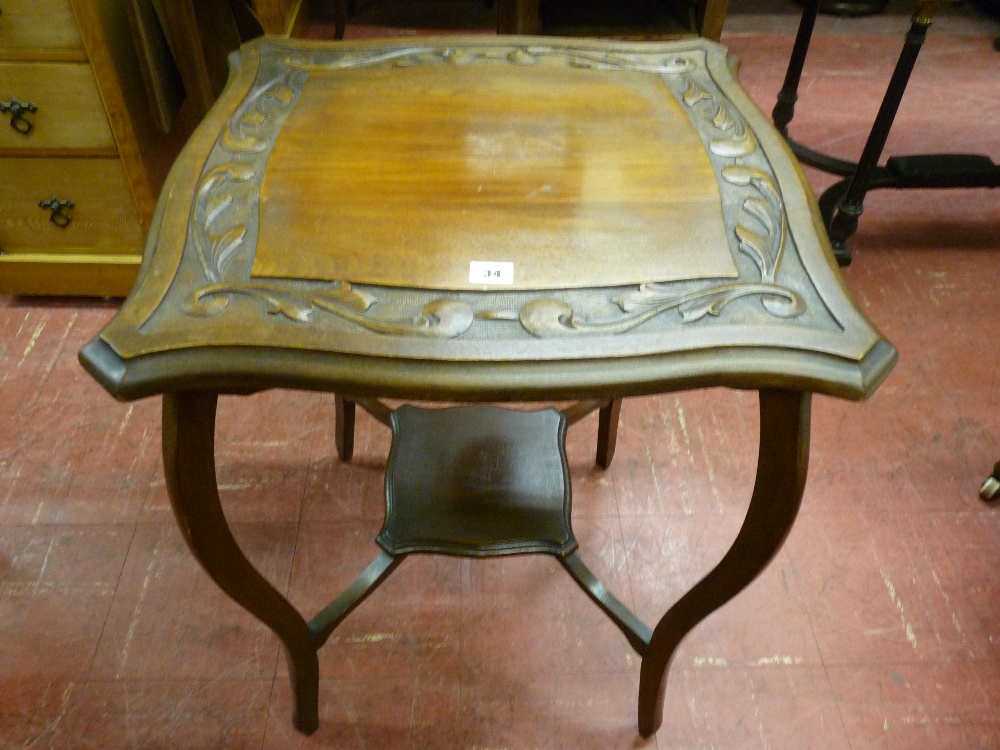 AN EDWARDIAN CARVED MAHOGANY SIDE TABLE, the shaped near square top with leaf decoration on swept