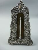 A SILVER EASEL THERMOMETER STAND with raised all over floral decoration and the thermometer set into