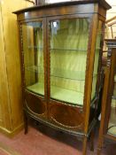 AN EDWARDIAN MAHOGANY BOW FRONT CHINA DISPLAY CABINET, the glazed doors with shaped edging and