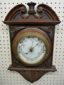 A VINTAGE OAK WALL MOUNTED ANEROID BAROMETER with porcelain dial and classically carved frame, 40