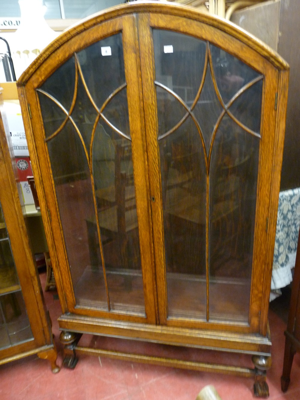 A VINTAGE OAK DOME TOPPED BOOKCASE circa 1930 with twin eight panel doors on turned and carved
