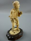 A LATE 19th CENTURY JAPANESE CARVED IVORY FIGURE of a standing man, sectional carving applied to