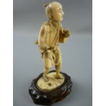 A LATE 19th CENTURY JAPANESE CARVED IVORY FIGURE of a standing man, sectional carving applied to