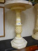 A CARVED ALABASTER CIRCULAR STAND, the 40 cms top on a pineapple column and stepped base, 61 cms