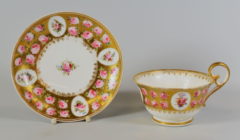 A NANTGARW PORCELAIN CUP & SAUCER decorated with pink roses and floral sprays to four cartouches and