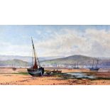 PETER GHENT watercolour - numerous beached boats and figures in an estuary with town and mountain