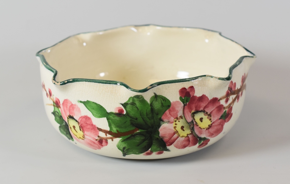 LLANELLY POTTERY BOWL painted with wild-roses and having a crimped rim, stencilled mark to base,