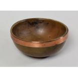 A WELSH SYCAMORE TREEN CAWL BOWL of simple footed form and having a copper reinforcement band, 17cms