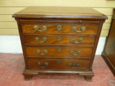 A COMPACT GEORGIAN MAHOGANY BACHELOR'S CHEST of four long graduated drawers all with patterned brass