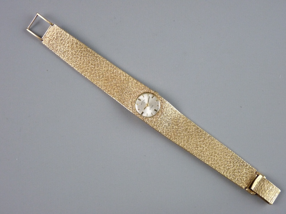 A LADY'S NINE CARAT GOLD CIRCULAR DIAL ROTARY WRISTWATCH with incorporated bark effect graduated